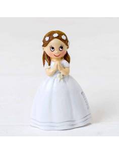 Imán niña vestida de blanco con una corona de flores en el pelo, lleva las manos juntas rezando